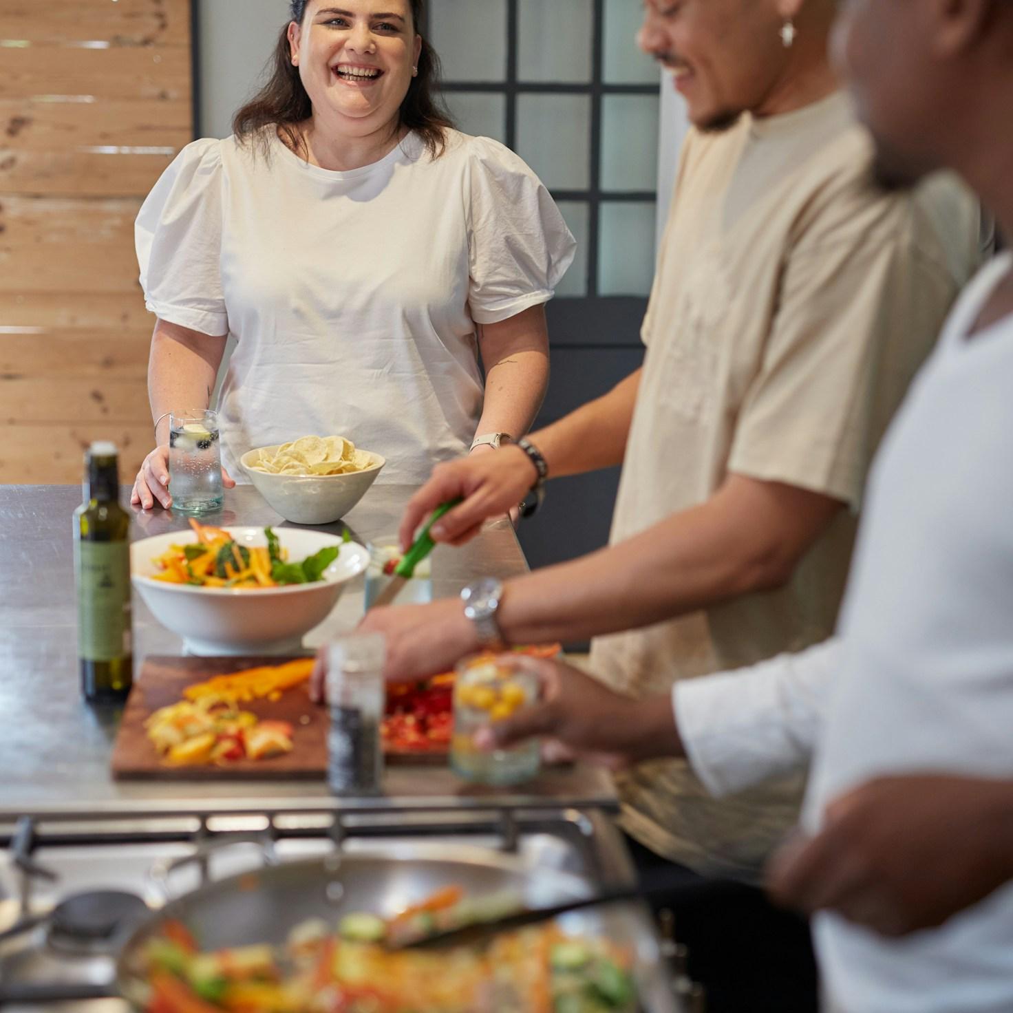 Diverse group of community members sharing a meal together, showcasing the social bonds formed through collaborative cooking
